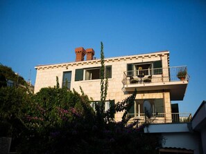Stunning two-story building with a flat roof and symmetrical facade, surrounded by lush greenery.