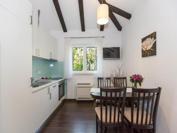 Enjoy meals in the compact kitchen with a stove, microwave, and dining area featuring a table and chairs.