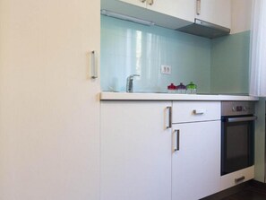 Enjoy cooking in this well-equipped kitchen with a stainless steel oven, glass backsplash, and ample countertop space.