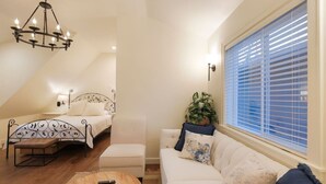 A bedroom with a bed, a bench, a sofa, a potted plant, and a chandelier. - Campus/Central location on Legion Ave! w/garage (Chico)