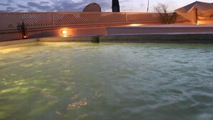 A swimming pool with a view of a building in the background. - Riad Bensaleh 56 (Marrakech)