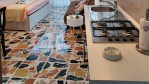 A modern hotel room with a bed, a small sofa, a kitchen area with a stove, and a large window with curtains. - Moments of Serenity (Rocca San Giovanni)