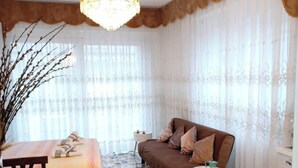 A cozy living room with a brown sofa, a dining table set with plates and glasses, and a chandelier. - Moments of Serenity (Rocca San Giovanni)