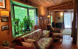 A cozy wooden cabin interior with a sofa, chairs, and a dining table. - Mai's Cabin! (Kerhonkson)