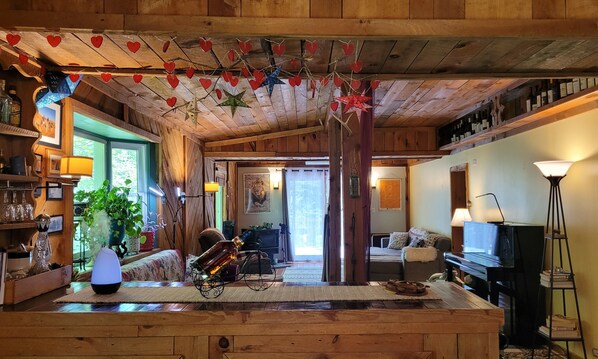 A cozy wooden interior with a bar area, a sofa, and a television. - Mai's Cabin! (Kerhonkson)