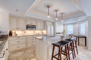 Enjoy cooking in this well-equipped kitchen with a central island, sink, and microwave.