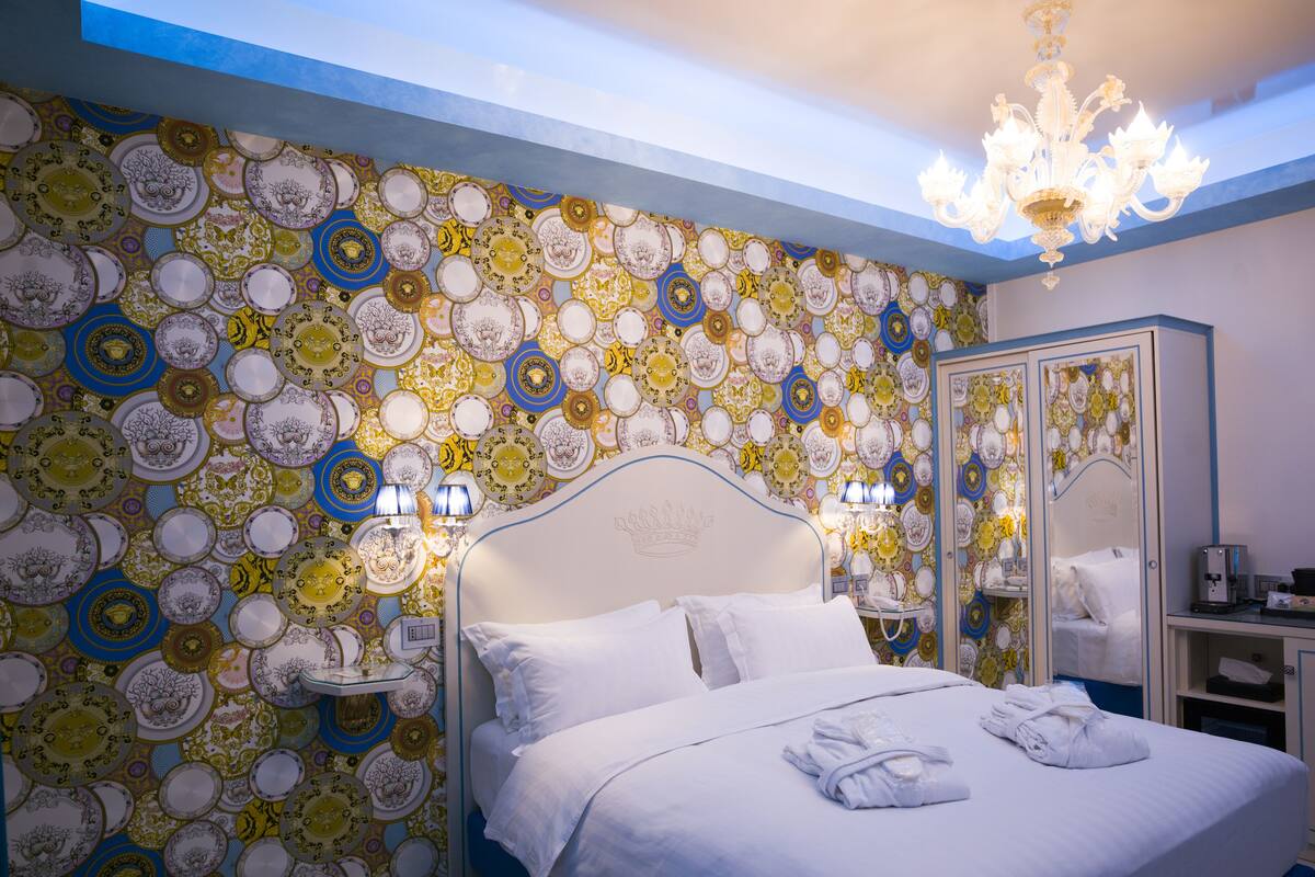 Une chambre d’hôtel avec un lit, une armoire et un mur décoré d’assiettes.