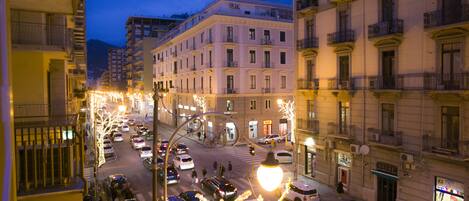 A city street at dusk with illuminated trees and buildings.