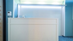 Un comptoir d’accueil orné d’un emblème en forme de couronne, doté d’un écran numérique et d’un présentoir à cartes.