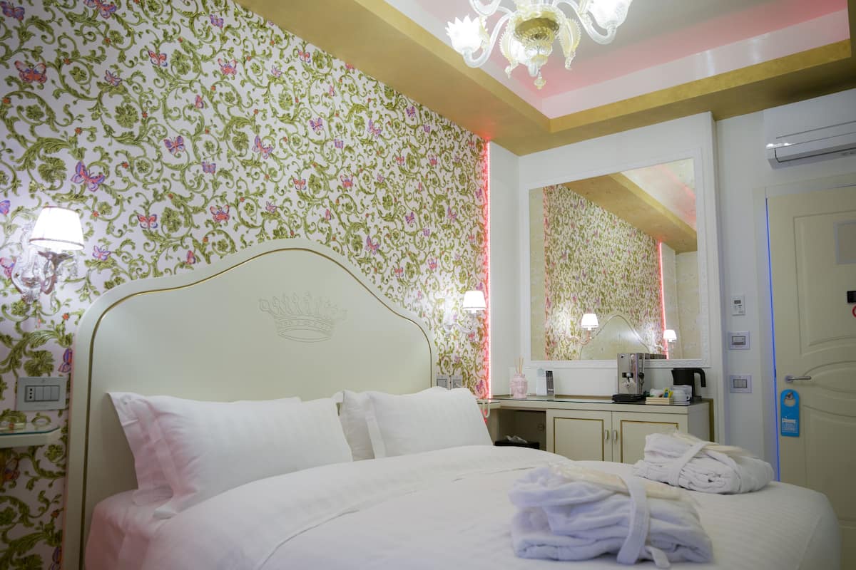 Une chambre d’hôtel avec un lit, une table de chevet et un miroir.