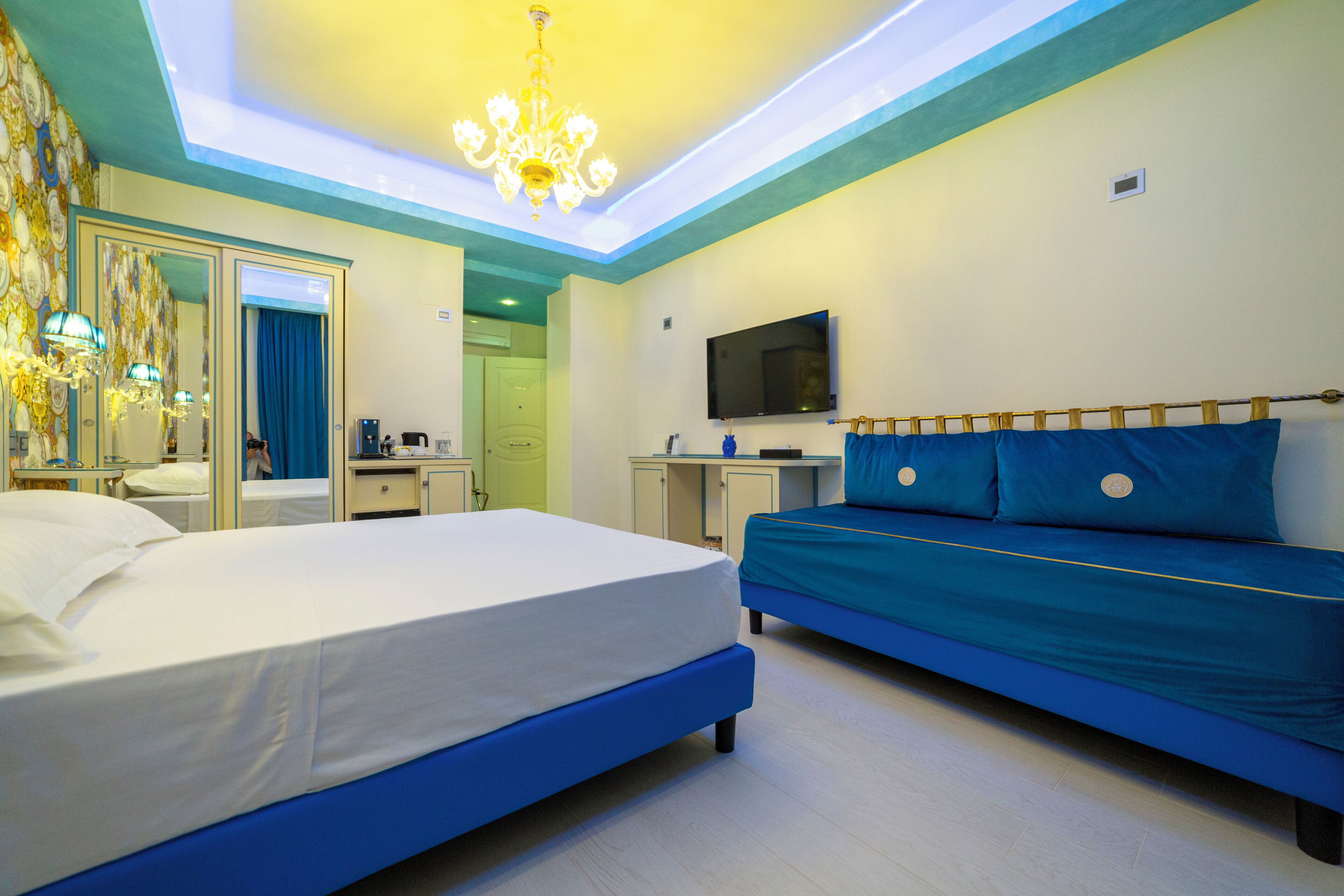 Ein modernes Hotelzimmer mit einem großen Bett, einem Schreibtisch, einem Fernseher und einem durch eine Tür erkennbaren Badezimmer.