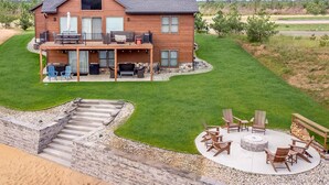 A two-story house with a covered patio, outdoor seating, and a fire pit. - Kokomo Cabin: Cozy Fires, Family Fun & Lake Views (Germantown)