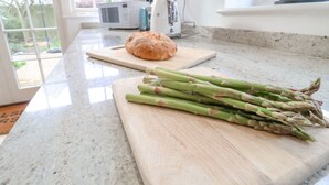Un plan de travail de cuisine avec une miche de pain et des asperges sur une planche à découper.