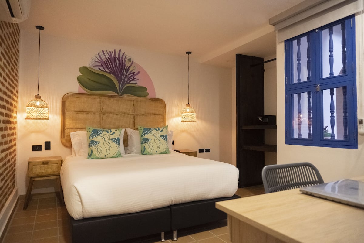 A bedroom with a bed, bedside tables, a desk, and a chair.