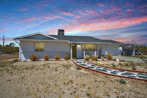 A single-story house with a sloped roof, a front porch, and a small front yard with landscaping.