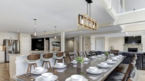 A spacious dining area with a long table set for a meal, surrounded by comfortable seating. - Luxurious Chalet in Blakeslee: Game Room, Hot Tub, Lake Access, Fire pit (Blakeslee)