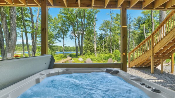 Un jacuzzi con vistas a un lago y un bosque.