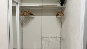 Un vestidor amplio con estantes abiertos, una barra para colgar ropa y un zapatero.