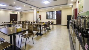 A spacious dining area with multiple tables and chairs, a vending machine line, and a large window providing natural light. - Greentree Inn Qinhuangdao Haigang District Railway Station Square Express Hotel (Qinhuangdao)