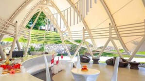 A modern, tent-like structure with white furniture and a view of greenery outside. - Xishuangbanna Visible Zeqi Tent Hotel (Menghai)