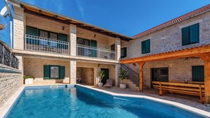 A two-story stone building with a swimming pool, balconies, and outdoor seating. - Beautiful home in Benkovac (Benkovac)