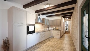 A modern kitchen with white cabinetry, a built-in oven, and a wooden floor. - Beautiful home in Benkovac (Benkovac)