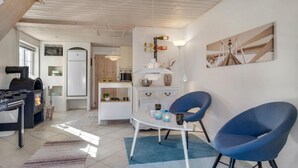 A modern kitchen with a built-in stove, white cabinets, and a dining area with blue chairs. - Lovely home in Pandrup with WiFi (Pandrup)
