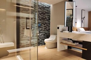 Une salle de bain moderne avec une douche à parois de verre, des toilettes et un meuble-lavabo avec un miroir.