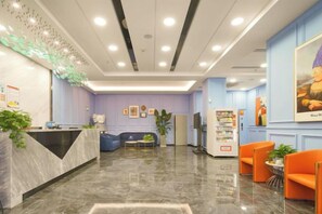 A hotel lobby with a reception desk, seating area, and a vending machine. - The Sleep Ziihome Hotel (Guiyang)