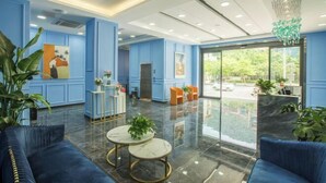 A modern lobby with blue walls, marble flooring, and seating areas. - The Sleep Ziihome Hotel (Guiyang Xiaohe Shanshui Qiancheng) (Guiyang)