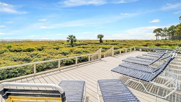 A deck with sun loungers overlooking a natural landscape. - Family Beachfront Retreat: Walk to Coligny Plaza with Side Ocean Views (Hilton Head Island)