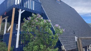 A house with a steeply pitched roof, a visible chimney, and a blue balcony. - Cabin in the Woods with Hot Tub, Incredible Views, Fireplace, Foosball, Fire Pit (Green Mountain Falls)