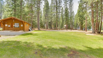 Situated in a forested area, this lodge offers a peaceful retreat with a front porch and a simple, rustic design.