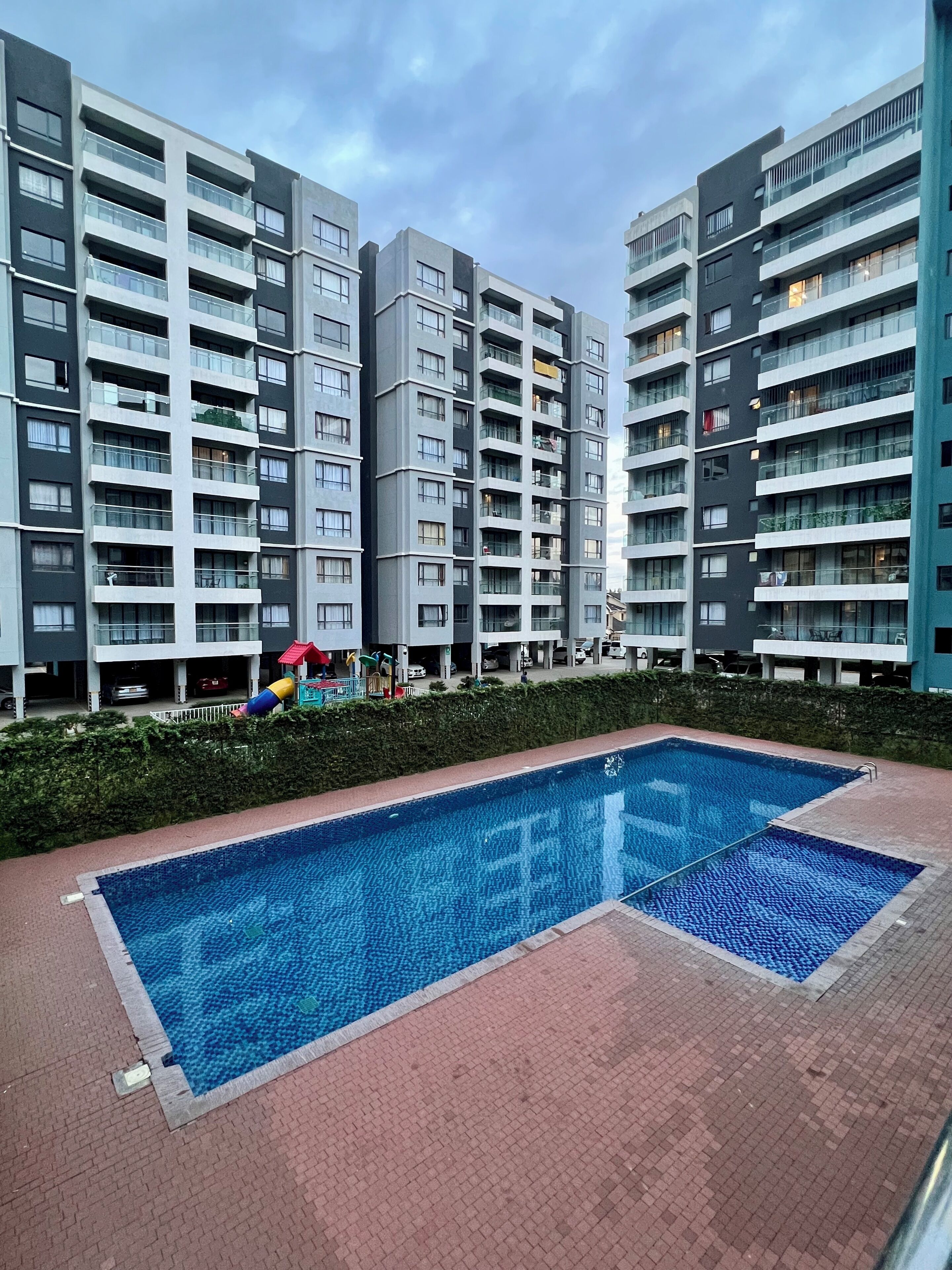 A modern apartment building with a swimming pool.