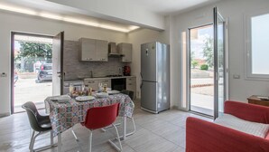 Una cocina moderna con comedor, refrigerador y vista al exterior.