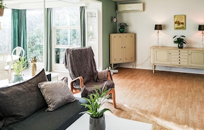 Un salon comprenant un canapé, un fauteuil, un meuble et une table à manger.