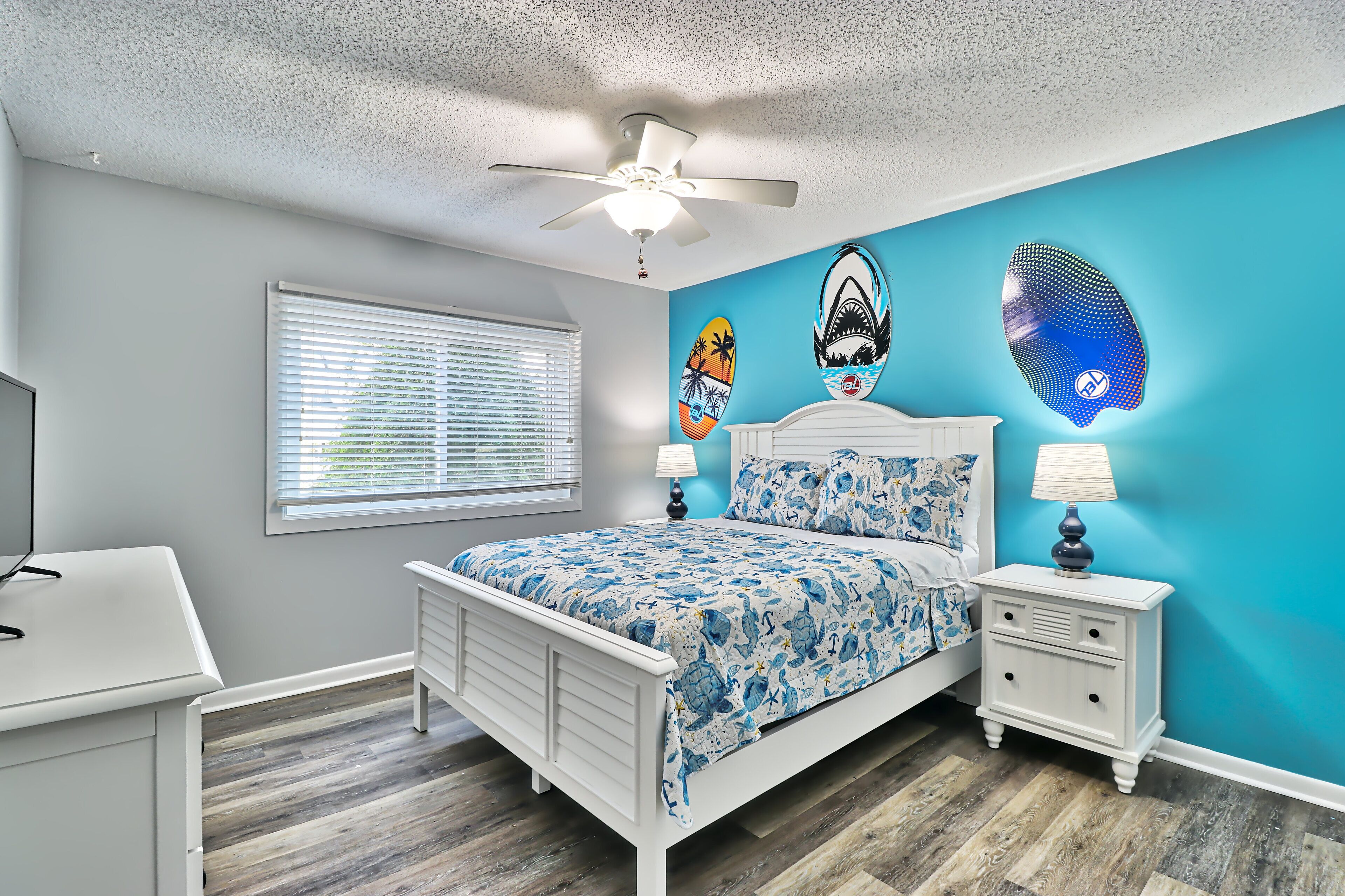 A bedroom with a bed, nightstand, and a ceiling fan.