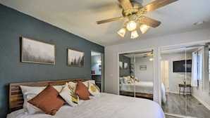 A bedroom with a large bed, a ceiling fan, and two framed pictures on the wall. - Spacious, Cozy 3 Bedroom 2 bath North End Home (Tacoma)