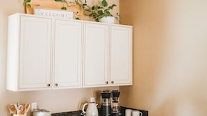 A kitchen with white cabinets, a wooden ceiling, and a welcome sign above the cabinets. - 3bdrm, 3bath in forest,  12 min to downtown Sequim,Wifi, Fire pit, Sauna, Hottub (Sequim)