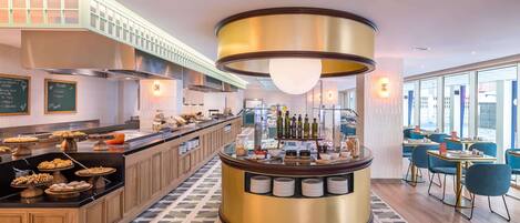 A modern hotel lobby with a central bar area, buffet with various food items, and seating arrangements.