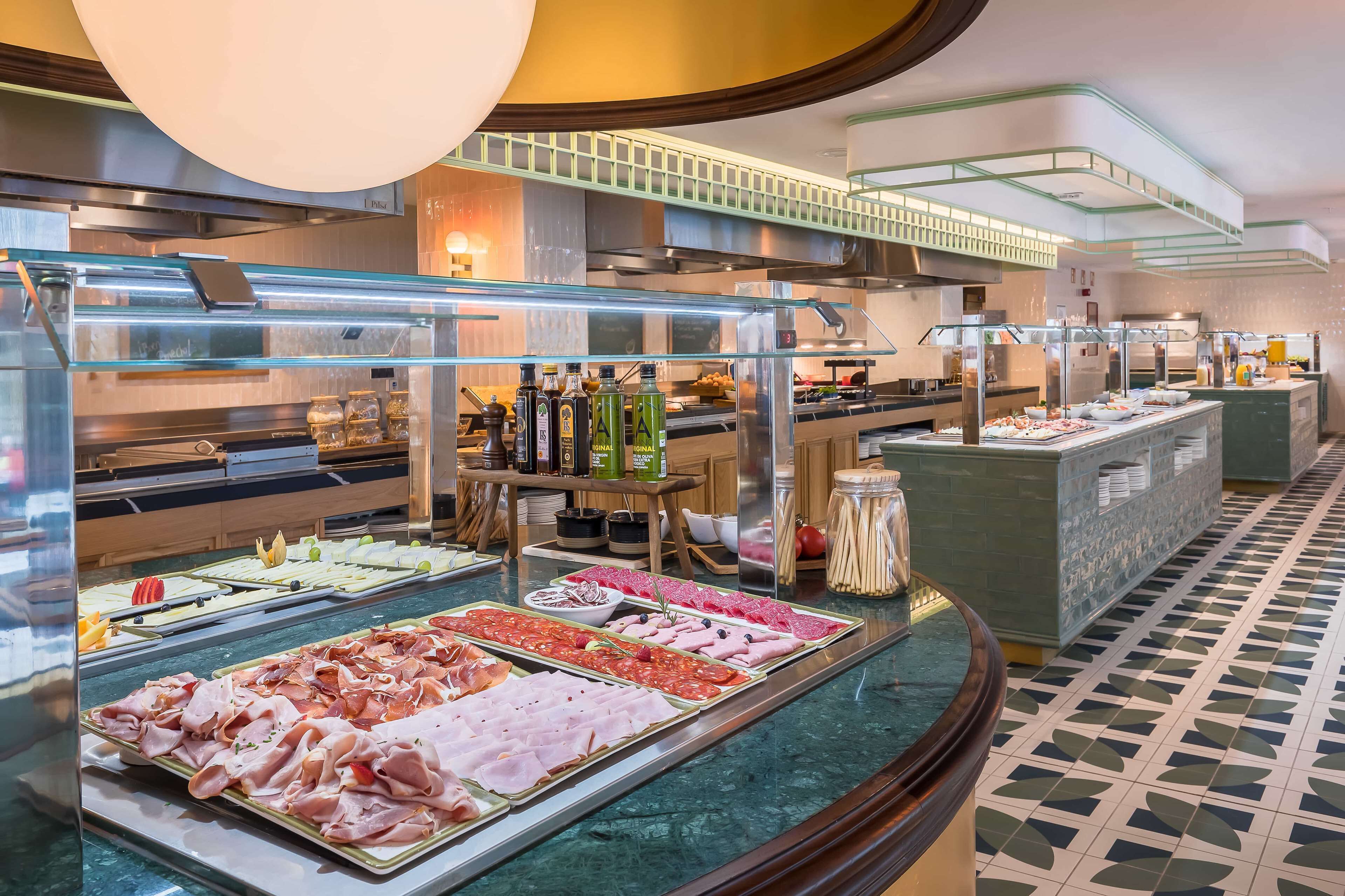 A buffet area with various food options, a counter with beverages, and a tiled floor.