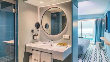Un baño moderno con un espejo grande, dos lavamanos y una ducha.