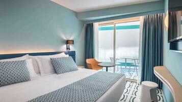 Una habitación de hotel con una cama, una mesita, una silla y vistas al exterior.