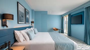 Una habitación de hotel moderna con una cama grande, un escritorio y un televisor.
