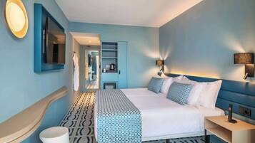 Una habitación de hotel moderna con una cama grande, una mesita de noche, un espejo y un armario.