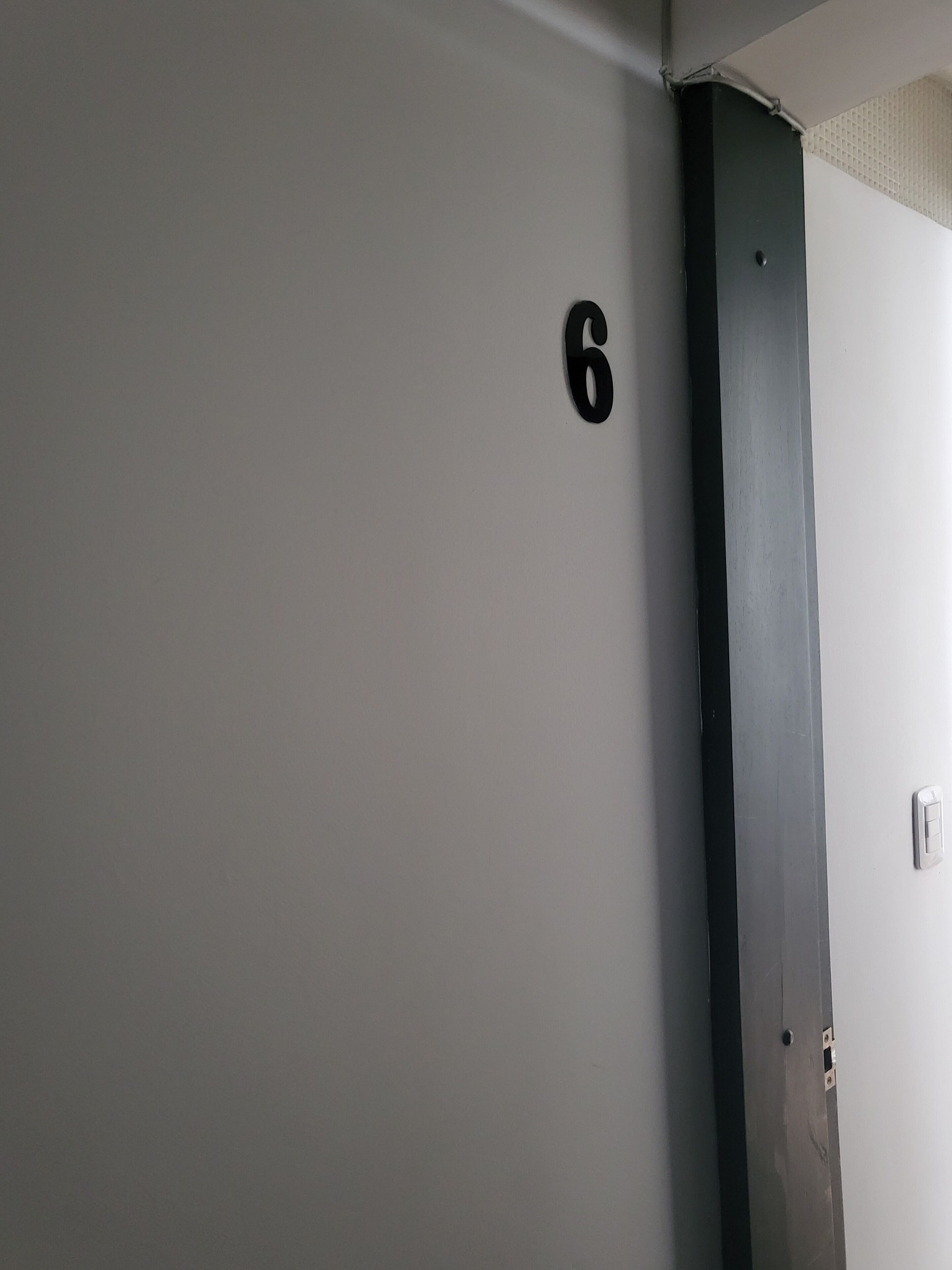 A wall with a number '6' indicating room number.