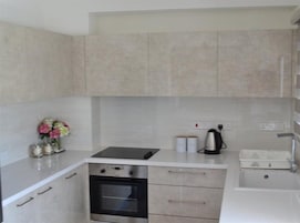 A compact kitchen with a built-in oven, a sink, and a countertop.