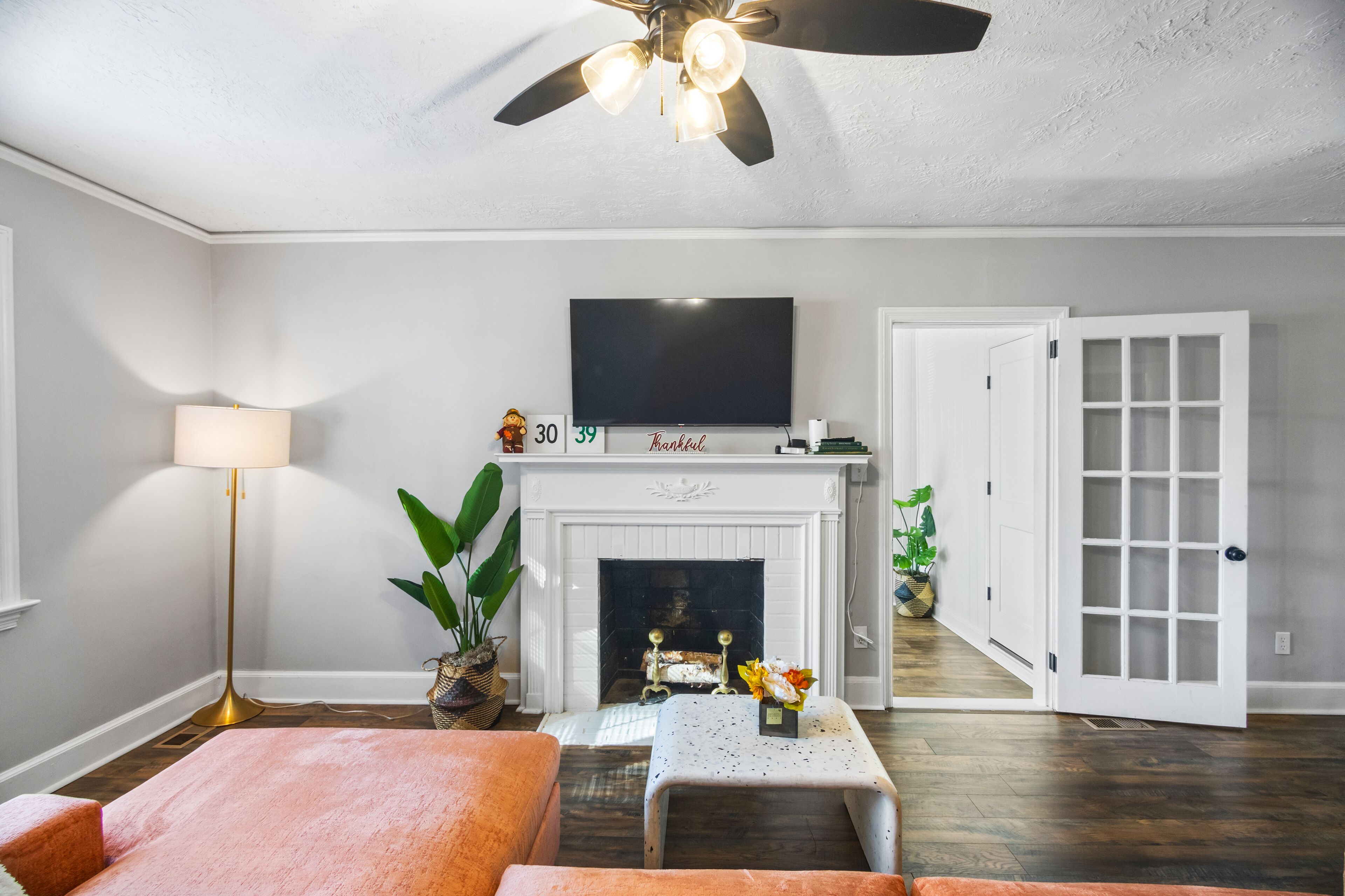 Ein Wohnzimmer mit Kamin, Fernseher und Deckenventilator.