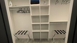 A walk-in closet with open shelving, a hanging rod, and two metal drying racks. - 
Oasis @ Black Mountain - Only 25 mins to Big White (Kelowna)
