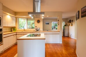 Una cocina moderna con una isla central, electrodomésticos integrados y vistas al exterior.